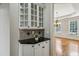 Butler's pantry with glass cabinets, granite countertops, and an elegant view of the dining room at 4046 Newhaven Ne Cir, Atlanta, GA 30319
