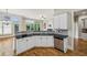 Open kitchen with white cabinets, black countertops, stainless steel appliances, and a view of the sunny living room at 4046 Newhaven Ne Cir, Atlanta, GA 30319
