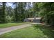 View of the front of the home with a long driveway and mature trees at 539 Karen Dr, Alpharetta, GA 30009
