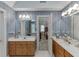 Spacious primary bathroom with double vanities, neutral wallpaper, and a glimpse into the bedroom at 711 Belgrave Ln, Tucker, GA 30084