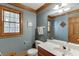 Cozy bathroom with framed window, tiled floors, and integrated vanity at 711 Belgrave Ln, Tucker, GA 30084