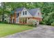 Traditional brick home with an attached garage and a well-maintained lawn at 711 Belgrave Ln, Tucker, GA 30084