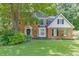 Charming two-story brick home with a manicured lawn and mature trees at 711 Belgrave Ln, Tucker, GA 30084