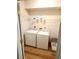 Convenient laundry room with a washing machine, dryer, shelving, and wood-look floors at 102 Ashbury Dr, Villa Rica, GA 30180