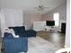 Spacious living room with a comfortable blue sectional couch, neutral walls, and wood-look floors at 102 Ashbury Dr, Villa Rica, GA 30180