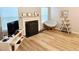 Cozy living room featuring a fireplace, wood-look floors, and a stylish papasan chair at 102 Ashbury Dr, Villa Rica, GA 30180
