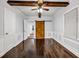 Open-concept living room with dark wood floors, beamed ceiling, and decorative sliding barn door at 1747 Parkhill Dr, Decatur, GA 30032