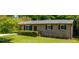 Charming brick home with manicured lawn, red door, and black shutters on a sunny day at 3570 Briar Dr, Lithia Springs, GA 30122