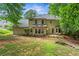 The backyard features a well-maintained lawn, mature trees, and an elevated stone patio at 1863 Wicks Valley Ne Dr, Marietta, GA 30062