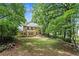 The backyard features a sprawling lawn, mature trees and landscaping, and a stone patio at 1863 Wicks Valley Ne Dr, Marietta, GA 30062