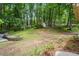 Expansive backyard featuring a retaining wall, lush lawn, and mature trees offering privacy and tranquility at 1863 Wicks Valley Ne Dr, Marietta, GA 30062