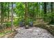 Inviting back patio with stone pavers, stacked stone wall, and comfortable seating around a fire pit at 1863 Wicks Valley Ne Dr, Marietta, GA 30062