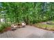 Enjoy backyard views from this stone patio, furnished with a small outdoor table and comfortable chairs at 1863 Wicks Valley Ne Dr, Marietta, GA 30062