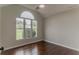 Bedroom featuring hardwood floors, a large arched window, and natural lighting at 250 Meadow View Dr, Grayson, GA 30017