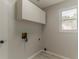 Bright laundry room with overhead cabinets, neutral walls, and convenient utility hookups at 250 Meadow View Dr, Grayson, GA 30017
