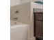 Corner view of a bright bathtub with granite counter top and dark wooden cabinets at 3291 Wild Basil Ln, Buford, GA 30519