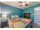 Bedroom featuring a ceiling fan, blue walls, carpeted floors and a side table with lamp at 3291 Wild Basil Ln, Buford, GA 30519