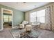 Bonus room featuring green accent wall, neutral paint, carpeted floors and rocking chairs at 3291 Wild Basil Ln, Buford, GA 30519
