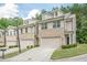 Attractive exterior view of townhomes, showcasing brick and siding, front lawns, garages, and inviting curb appeal at 3291 Wild Basil Ln, Buford, GA 30519
