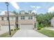 Wide exterior view of a townhome property, showing the garage, front lawns and surrounding trees and landscaping at 3291 Wild Basil Ln, Buford, GA 30519