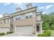 Inviting townhome exterior with brick accents, attached garage, well-maintained lawn, and architectural details at 3291 Wild Basil Ln, Buford, GA 30519
