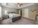 Spacious main bedroom featuring a trey ceiling, fan, ensuite bathroom, and modern furniture at 3291 Wild Basil Ln, Buford, GA 30519