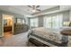 Main bedroom featuring tray ceilings, fan, large windows and ensuite bathroom at 3291 Wild Basil Ln, Buford, GA 30519