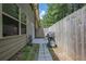 View of a backyard patio area featuring a grill, table and chairs next to a pathway and the side of the home at 3291 Wild Basil Ln, Buford, GA 30519
