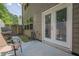 View of a back patio area, showing a grill and chairs outside of a set of exterior doors and a stone pathway at 3291 Wild Basil Ln, Buford, GA 30519