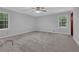 Spacious bedroom with plush carpeting, neutral walls, ceiling fan, and two windows with treed views at 6896 Heardsville Rd, Cumming, GA 30028