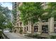 Building entrance with architectural columns and a well-manicured landscape at 75 Ponce De Leon Ne Ave # 1004, Atlanta, GA 30308