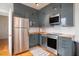 Modern kitchen with stainless steel appliances, gray cabinets, and wood countertops at 75 Ponce De Leon Ne Ave # 1004, Atlanta, GA 30308