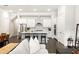 Open-concept kitchen featuring white cabinets, a large island, stainless steel appliances, and dark wood floors at 114 Batten Board Way, Woodstock, GA 30189