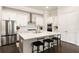 Well-lit kitchen with white cabinets, stainless steel appliances, and an island with seating at 114 Batten Board Way, Woodstock, GA 30189