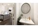 Stylish powder room features modern sink, decorative mirror, and a glimpse into the open-concept kitchen at 114 Batten Board Way, Woodstock, GA 30189