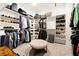 Spacious walk-in closet with custom shelving, hanging rods, and a central ottoman for added convenience at 114 Batten Board Way, Woodstock, GA 30189
