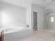 Bright bathroom featuring a soaking tub, separate shower with gold trim, and tile flooring at 1613 Brolington Ct, Conyers, GA 30013