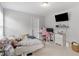 Neutral bedroom design featuring a bed, desk, TV, and good natural light at 1613 Brolington Ct, Conyers, GA 30013