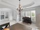 Dining room with wainscoting, a piano, a chandelier, and large windows that provide natural light at 1613 Brolington Ct, Conyers, GA 30013