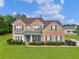 Charming two-story brick home with a well-manicured lawn and lush green landscaping at 1613 Brolington Ct, Conyers, GA 30013