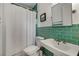 Cozy bathroom featuring green tiled walls, a classic white sink, and a shower with a white curtain at 311 Glendale Ave, Decatur, GA 30030