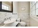 Charming powder room with marble accent wall, pedestal sink, and natural light at 311 Glendale Ave, Decatur, GA 30030