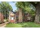 Lovely brick home with stone chimney, surrounded by lush trees and a green front yard at 311 Glendale Ave, Decatur, GA 30030
