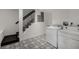Spacious laundry area with black and white patterned flooring, white appliances and stairs in the background at 311 Glendale Ave, Decatur, GA 30030
