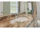 Bathroom vanity featuring a granite countertop, chrome faucet, white sink, and natural light from the window at 3663 Brookhaven Manor Crossing Ne, Atlanta, GA 30319