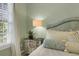 Bright bedroom featuring an upholstered headboard, mirrored nightstand, lamp, and natural light from the window at 3663 Brookhaven Manor Crossing Ne, Atlanta, GA 30319