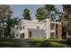 Modern two-story home boasts a sleek design, stone accents, and expansive windows, set on a lush green lawn at 680 Carriage Dr, Atlanta, GA 30328