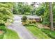 Ranch-style home with attached garage, mature trees, and lush landscaping creates a welcoming curb appeal at 680 Carriage Dr, Atlanta, GA 30328