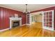 Charming living room with red accent walls, a brick fireplace, hardwood floors and french doors to other rooms at 680 Carriage Dr, Atlanta, GA 30328