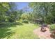 Backyard has a brick patio, grill, a lush green lawn and mature trees at 1908 E Roxboro Ne Rd, Atlanta, GA 30324